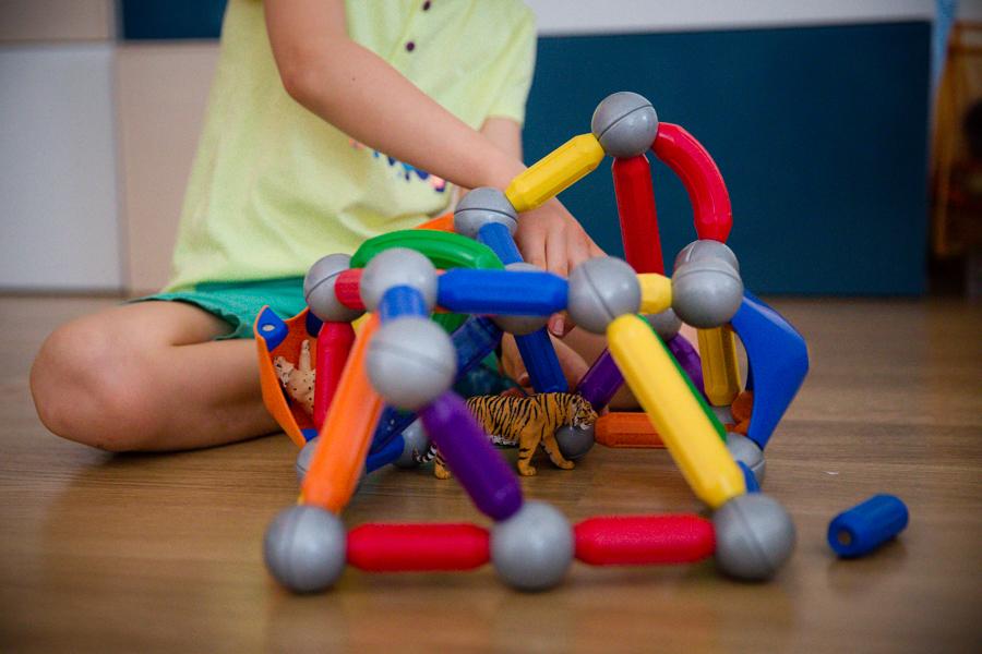 Child building with magnetic construction pieces